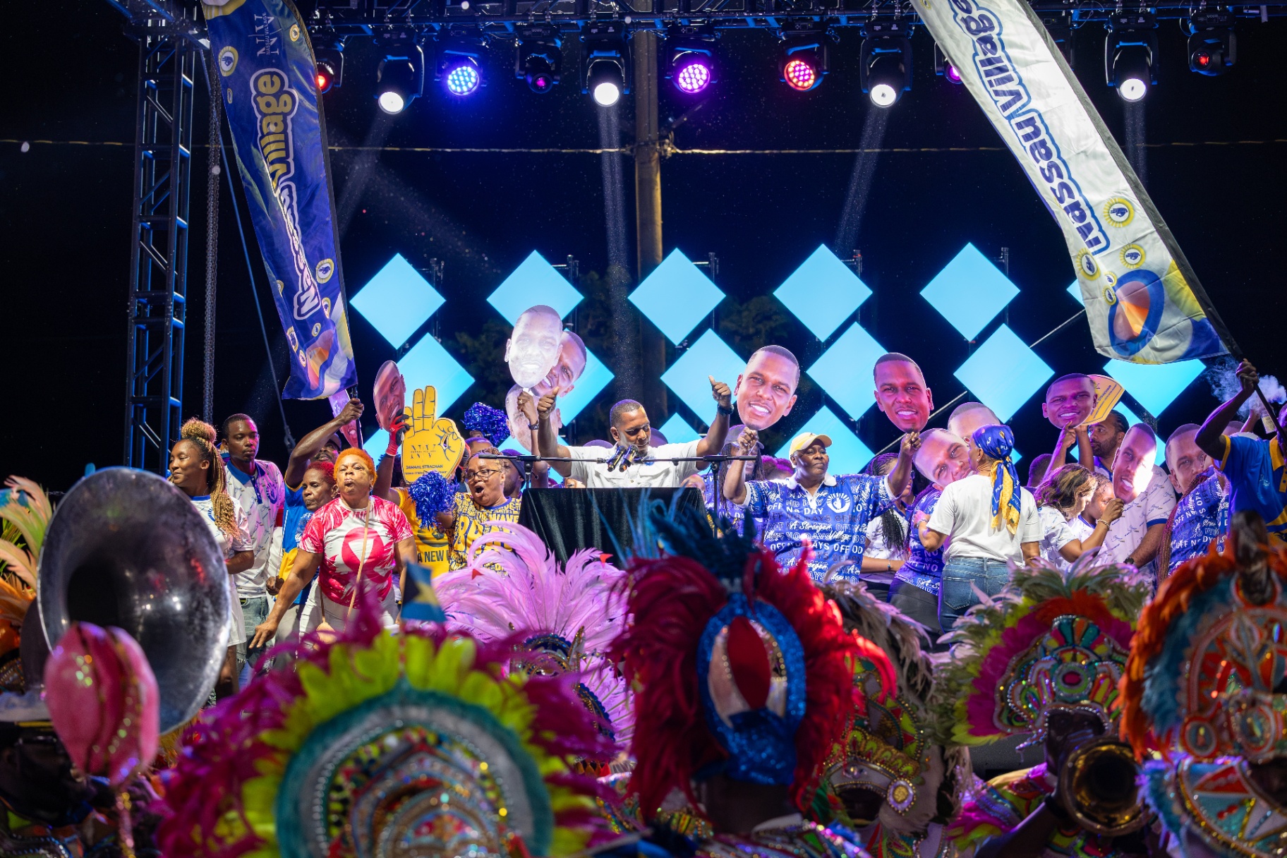 Wide stage shot with supporters, flags and Junkanoo costumes at Strachan nomination
